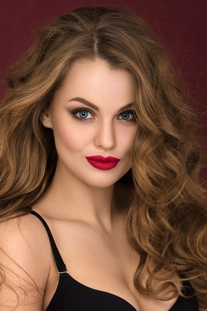 Portrait of coquette young curly woman with red lips
